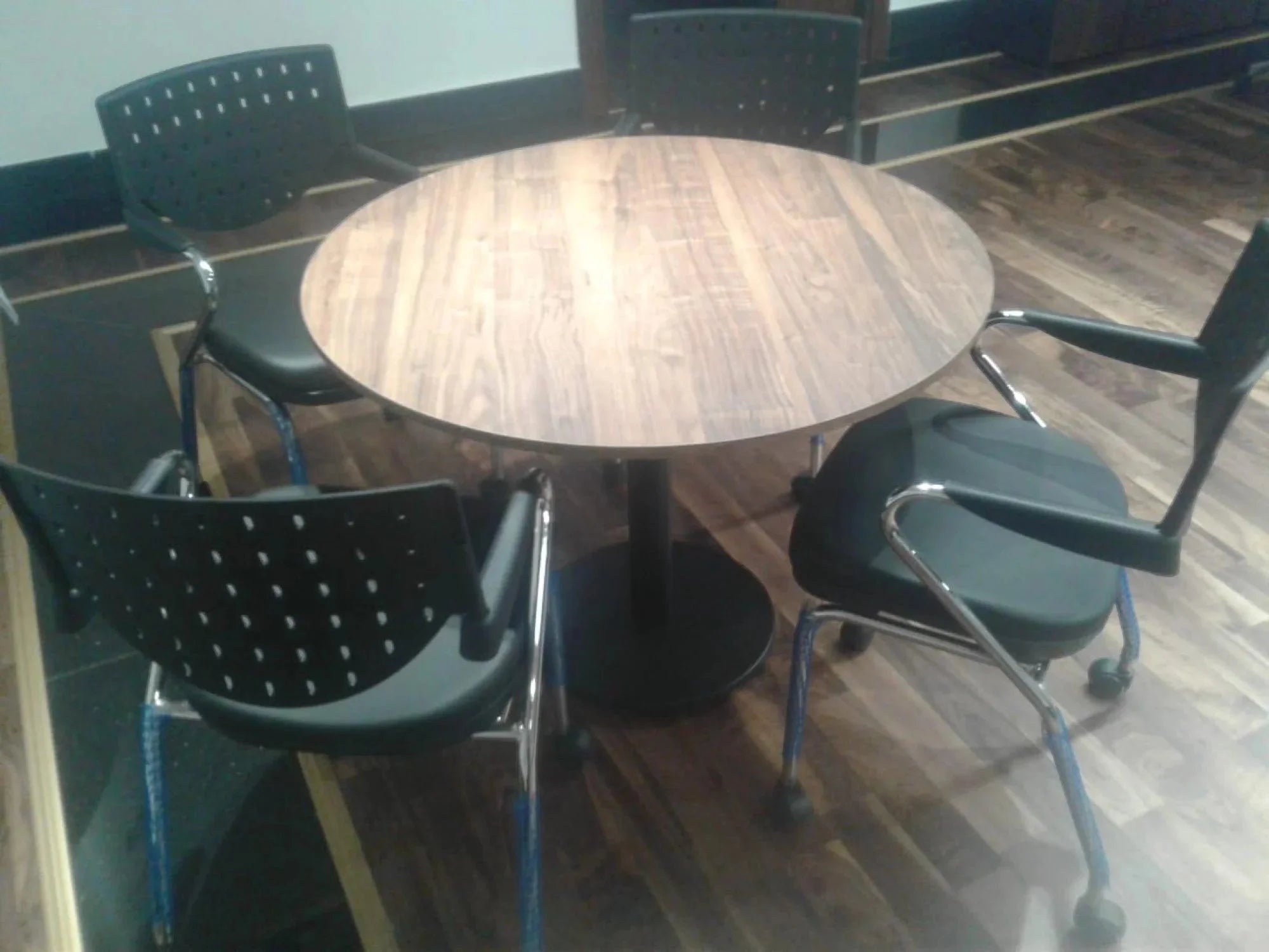 İstanbul Ofis Mobilya yuvarlak ahşap toplantı masası ve dört adet siyah modern ofis sandalyesi
